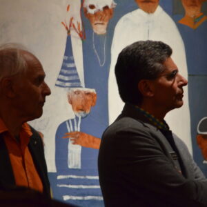 Two men in suit jackets listening to a speaker at a corporate event hosted by ARTISANworks in Rochester NY